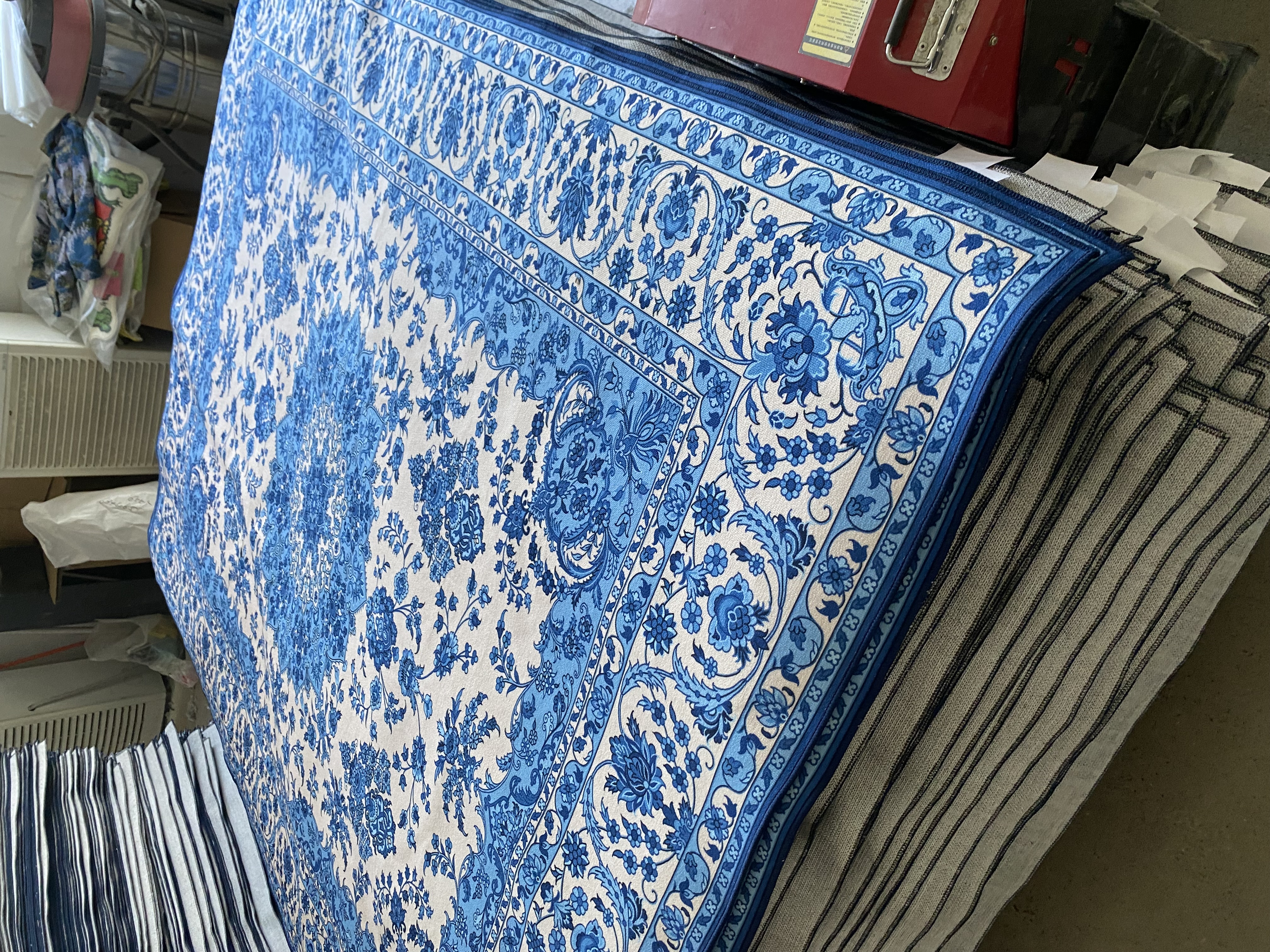Blue washable rug pattern stacked in factory