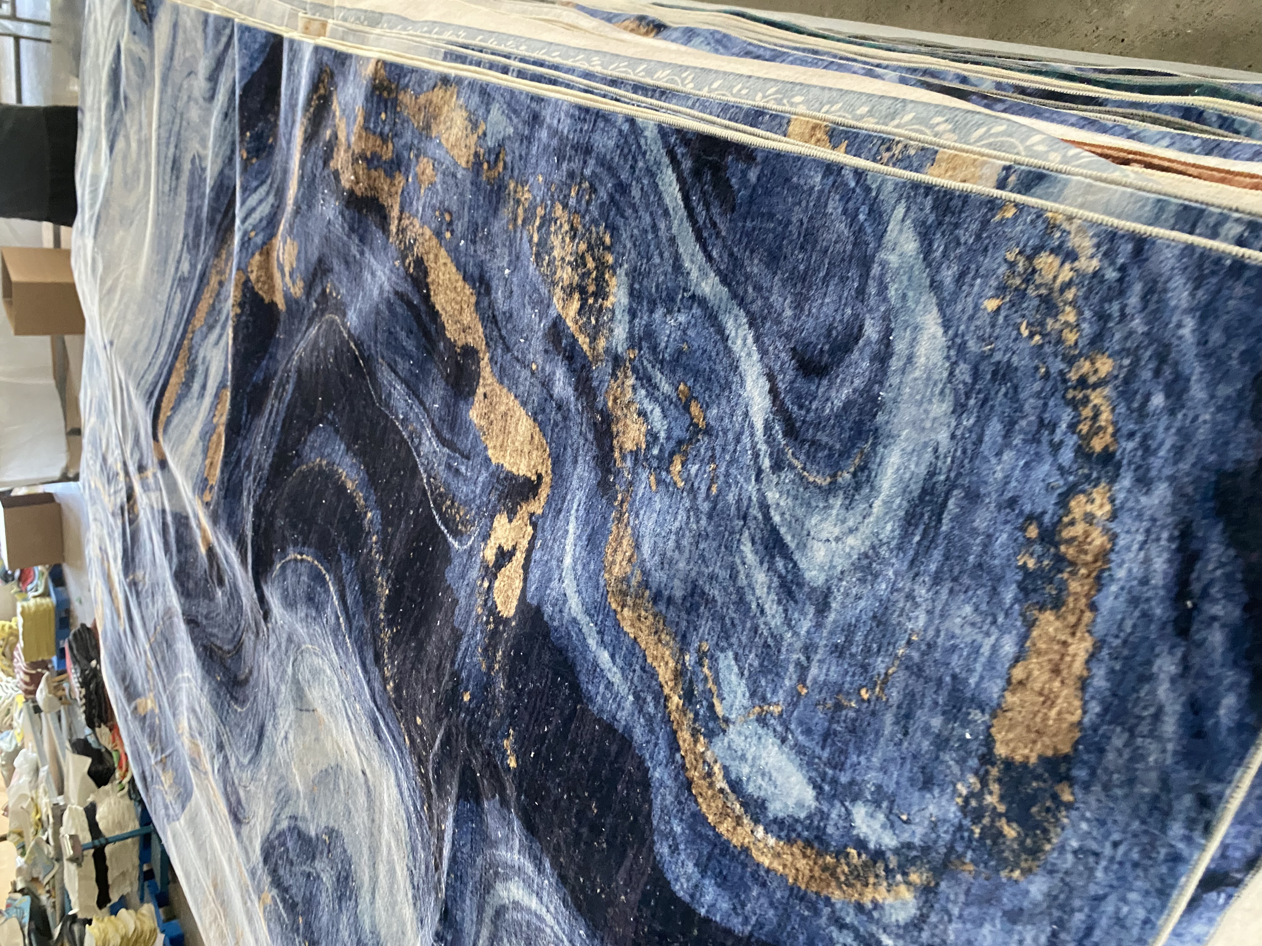 Blue washable rug production sample stacked in the factory